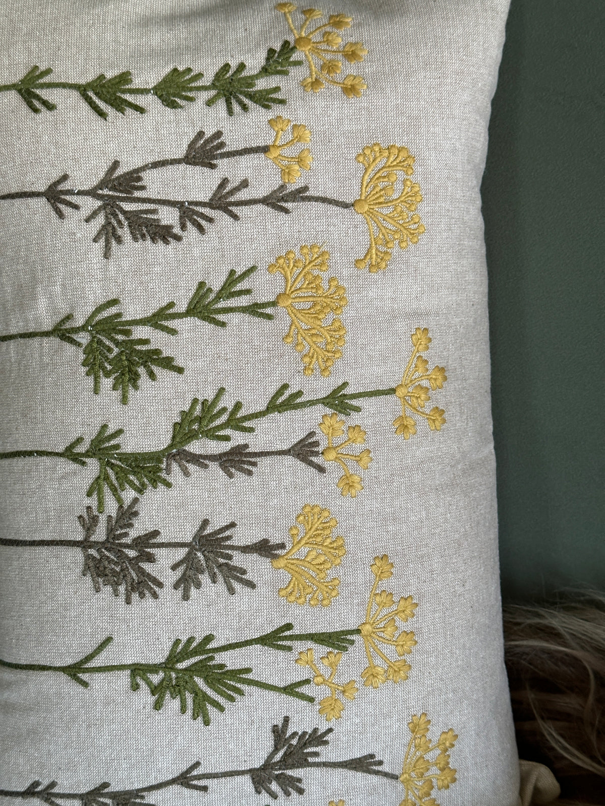 Kissen mit einer floralen Stickerei auf der Vorderseite. 100% Baumwolle.