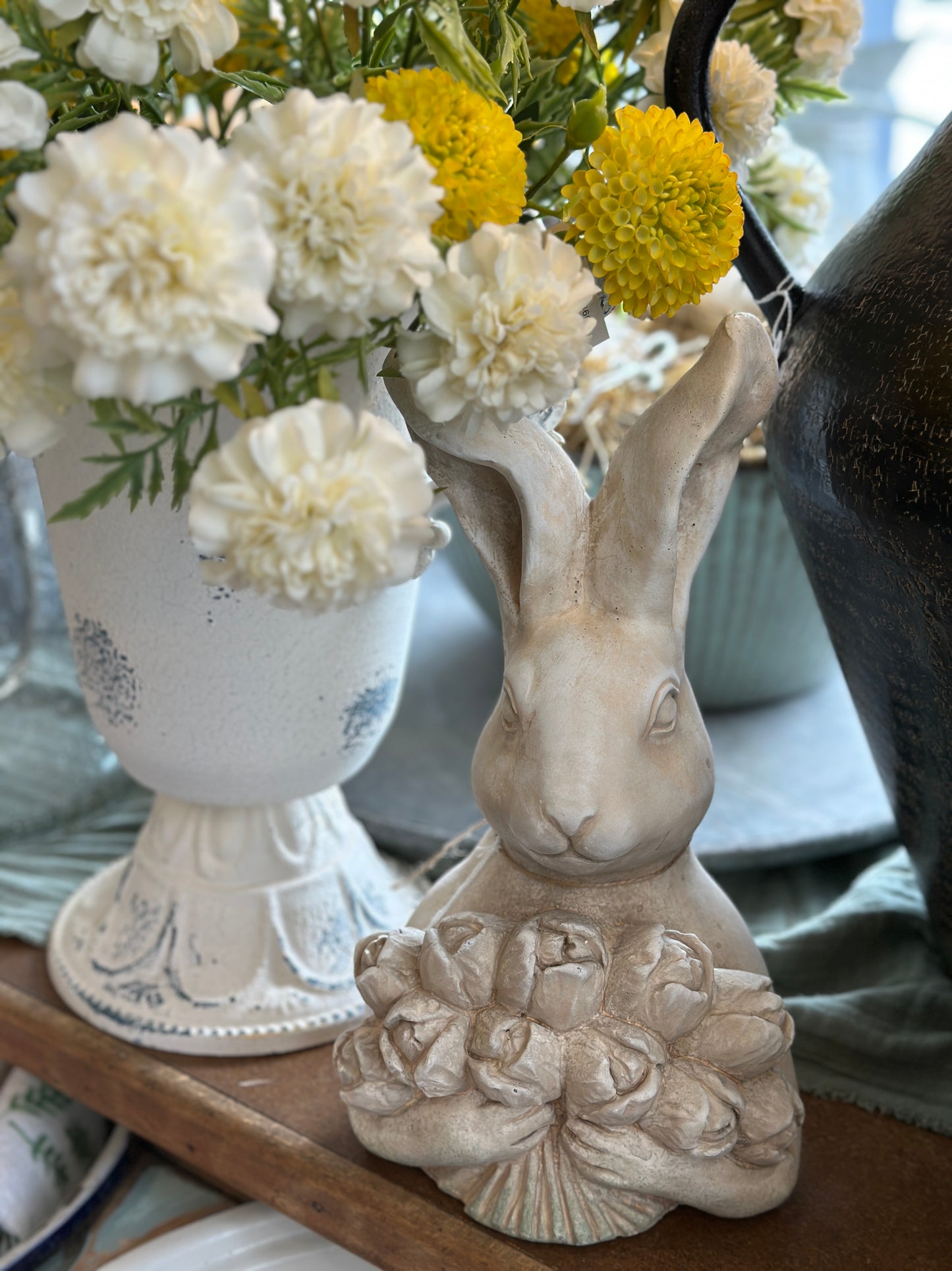 Hase aus Beton mit einem Tulpenstrauß
